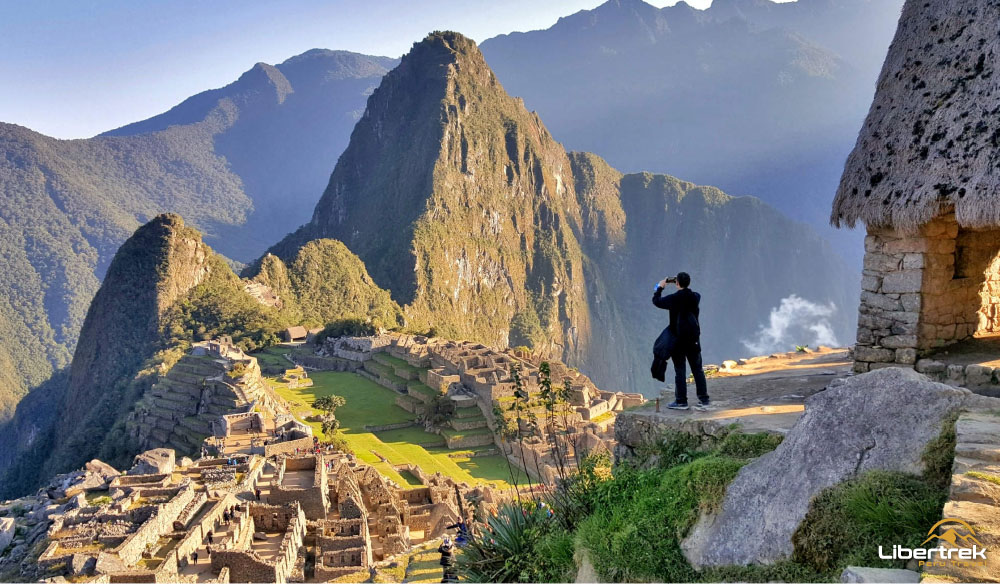 Visitante fotografiando la ciudadela inca desde la casa del Guardián